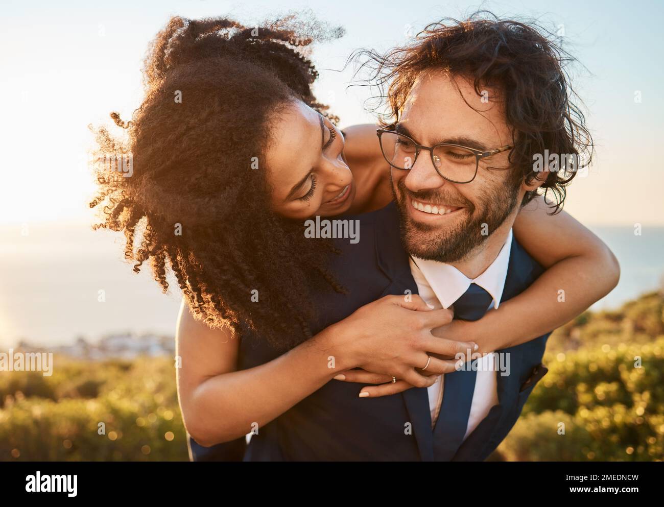 Hochzeit, gemischtrassige und Paare umarmen sich in der Natur, glücklich und aufgeregt, während sie Liebe, Anfang und Romantik feiern. Romantisch, verheiratet und glücklich, schwarz Stockfoto