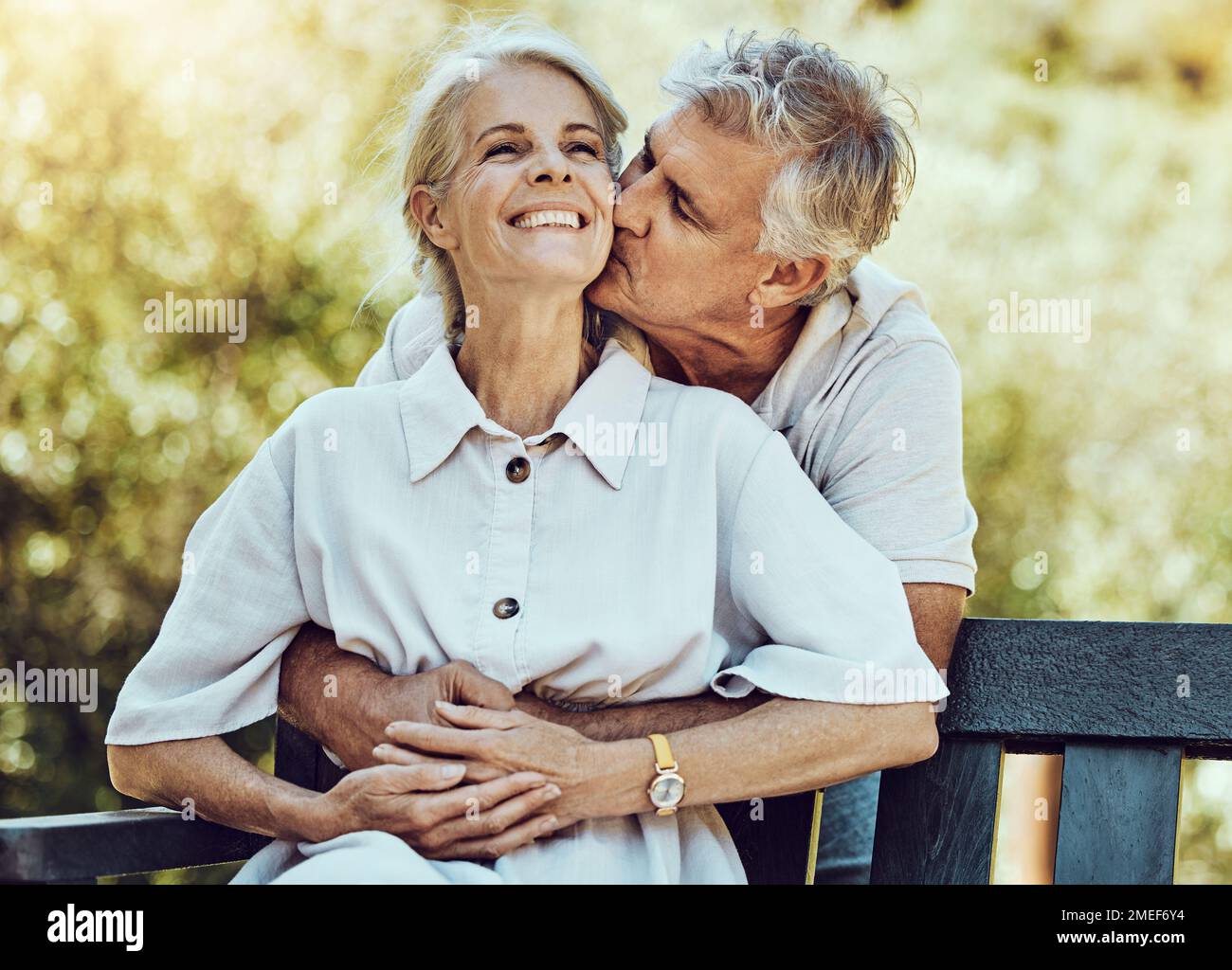 Glückliches altes Paar, Küsse und Umarmungen im Park mit Liebe, Ehe und Partnerschaft mit Ruhestand zusammen in der Natur. Ältere Menschen, Lebenspartner mit Pflege Stockfoto