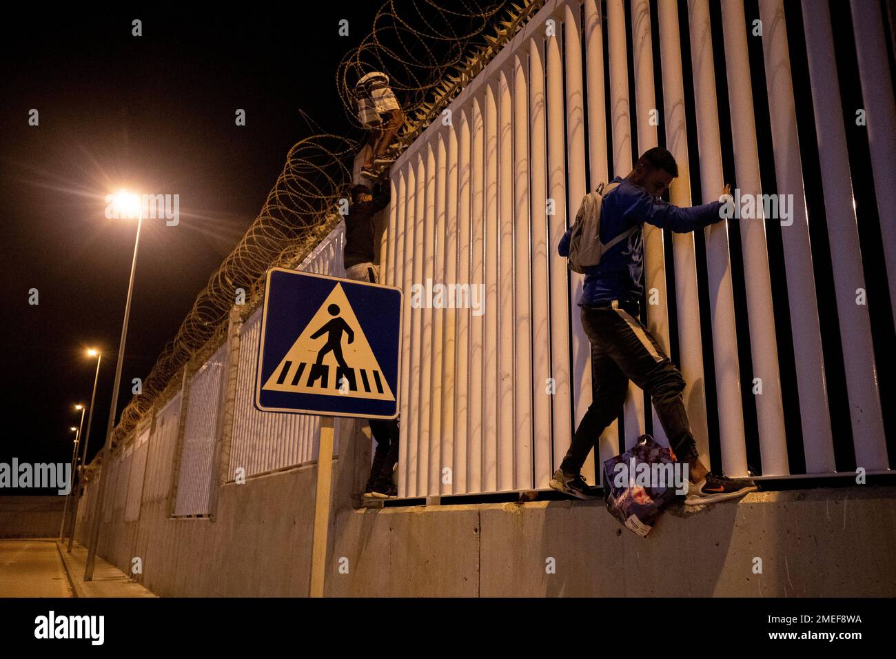 Migrants who recently crossed the Spain Morocco border, cross into the Ceuta commercial port, Spain, Wednesday, May 19, 2021. The group explained to The Associated Press their goal to reach the European ports of Malaga or Algeciras after hidding inside a commercial boat.(AP Photo/Bernat Armangue) Stockfoto