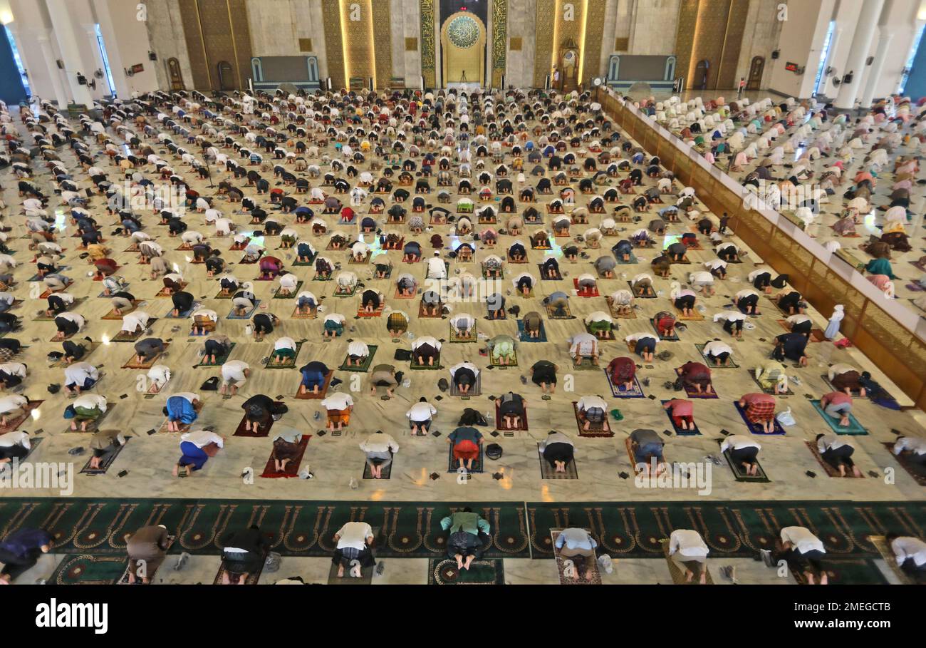 Indonesian Muslims pray spaced apart to help curb the spread of coronavirus outbreak during an Eid al-Fitr prayer marking the end of Ramadan at Al Akbar mosque in Surabaya, East Java, Indonesia, Thursday, May 13, 2021. Muslims celebrated the holiday in a subdued mood for a second year Thursday as the COVID-19 pandemic again forced mosque closings and family separations on the holiday marking the end of Islam's holiest month of Ramadan. (AP Photo/Trisnadi) Stockfoto