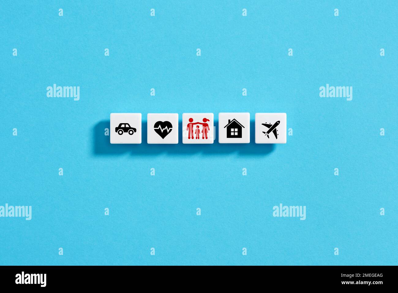 Weiße Blöcke mit Versicherungssymbolen auf blauem Hintergrund. Familien-, Lebens-, Auto-, Reise-, Kranken- und Hausversicherung. Stockfoto