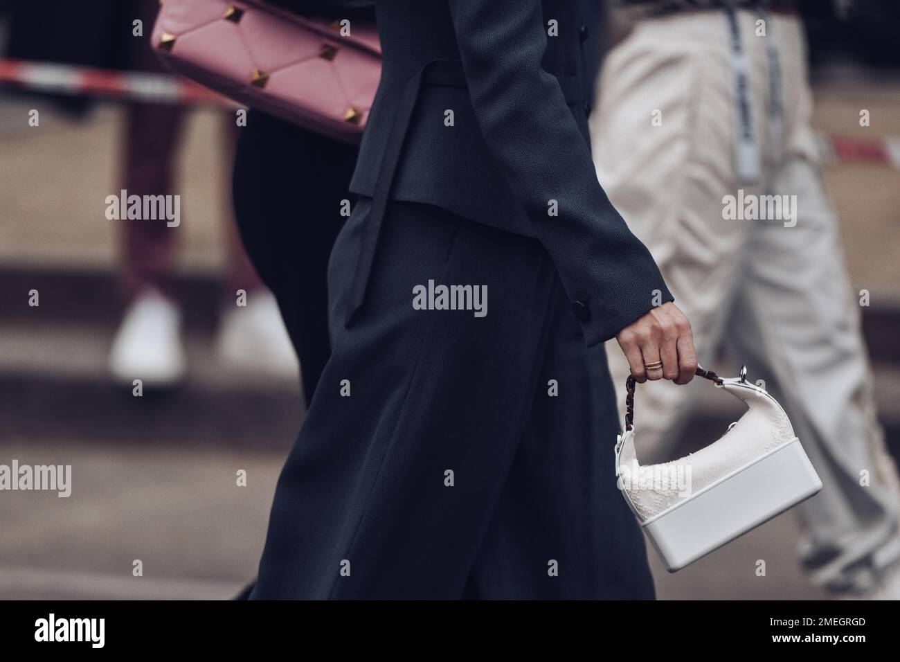Trendige Frau, die auf der Straße läuft, mit Handtasche Stockfoto