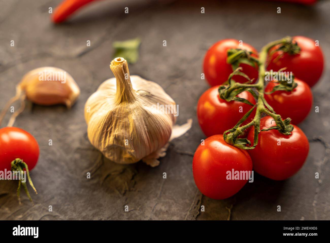 Köstliche reife Kirschtomaten, Chili-Paprika und Knoblauch zum Kochen Stockfoto