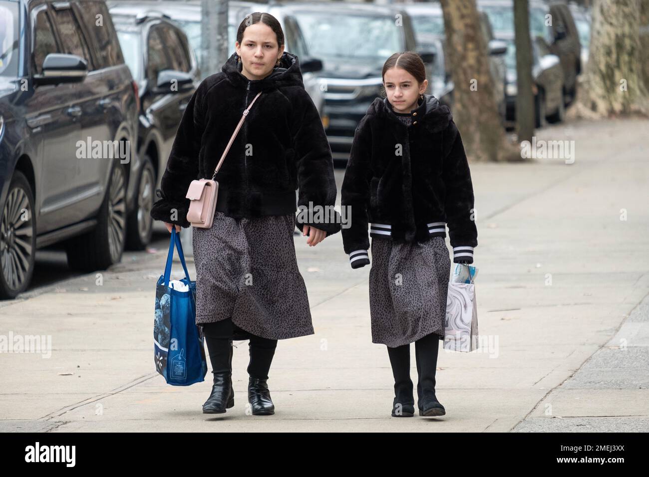 2 orthodoxe jüdische Schulmädchen gehen zusammen nach Hause und tragen dieselben Röcke, wahrscheinlich die Uniform ihrer Schule. In Brooklyn, New York, 2023 Stockfoto