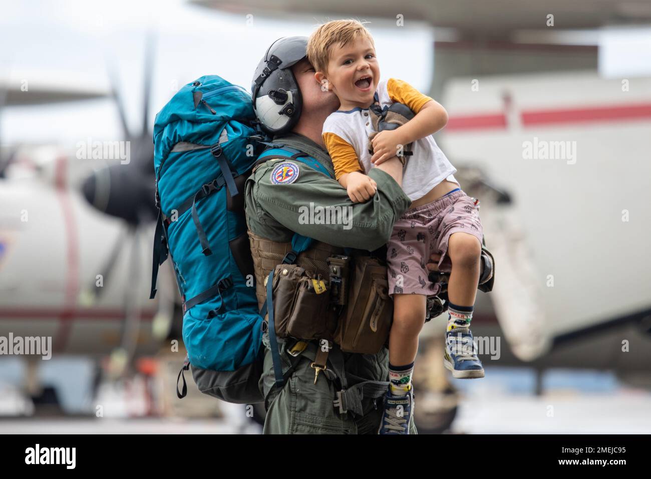 USA Leutnant Commander Der Marine. Greg Bowlin, ein Northrop Grumman E-2 Advanced Hawkeye Crewmitglied, dem Carrier Air Wing 5 zugeteilt, und Anderson, Indiana, trägt seinen Sohn nach seiner Rückkehr zur Marine Corps Air Station Iwakuni am 17. August 2022. Die Rückkehr des Luftflügels war der Abschluss ihres letzten Einsatzes an Bord der USS Ronald Reagan (CVN-76), wo sie Luftwaffe zum Schutz der US-Streitkräfte und Verbündeten bereitstellten, während sie Missionen zur Unterstützung eines freien und offenen Indopazifiks flogen. Stockfoto