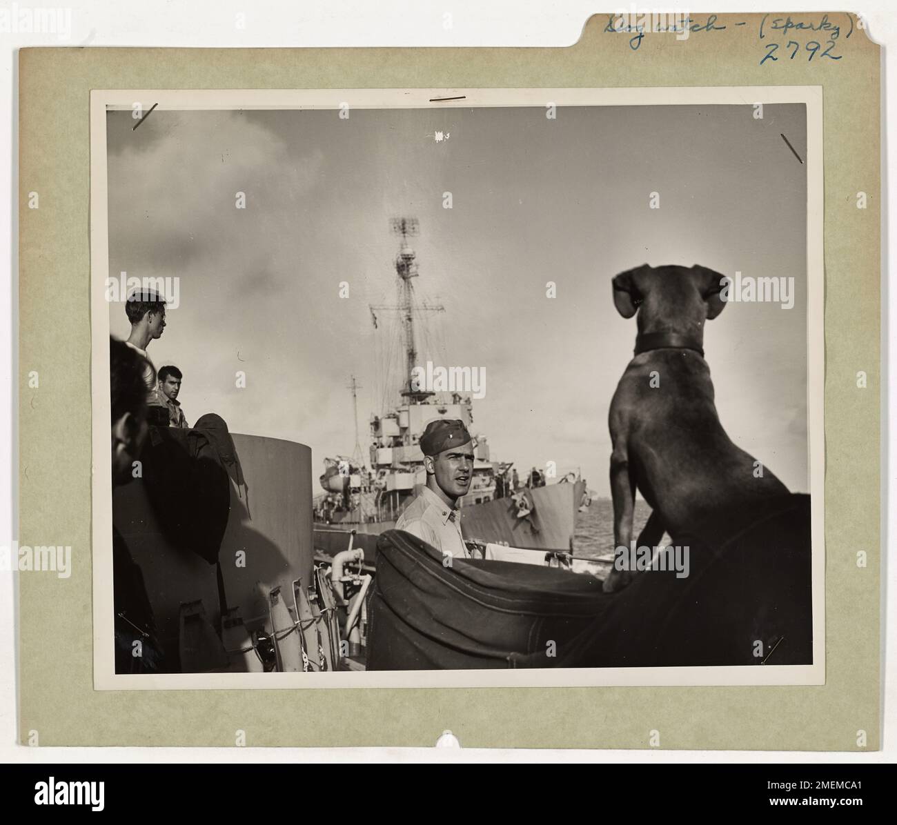 Auf Patrouille im Atlantik warnt Sparky, das Maskottchen eines Küstenwache-Kampfschneiders, auf ein sich näherndes Schiff. Mit aufgerissenen Ohren und wachsamen Augen verkörpert Sparky die Wachsamkeit der Crew der Küstenwache, die sich vor möglichen Bedrohungen schützt, neben Lieutenant Commander Ross P. Bullard. Stockfoto