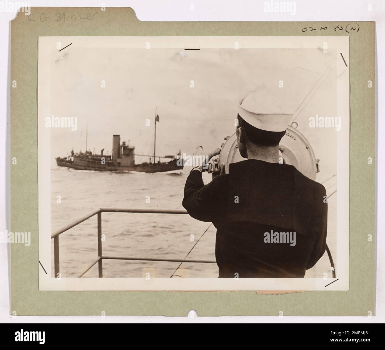 Ein Küstenwächter an Bord eines Subbusters signalisiert ein anderes Schiff der Küstenwache mit einem starken Blinker. Die Küstenwache verwendet Blinker und Semaphore, um während der Patrouillen zu kommunizieren, um die Feinderkennung durch Funksignale zu vermeiden. Stockfoto