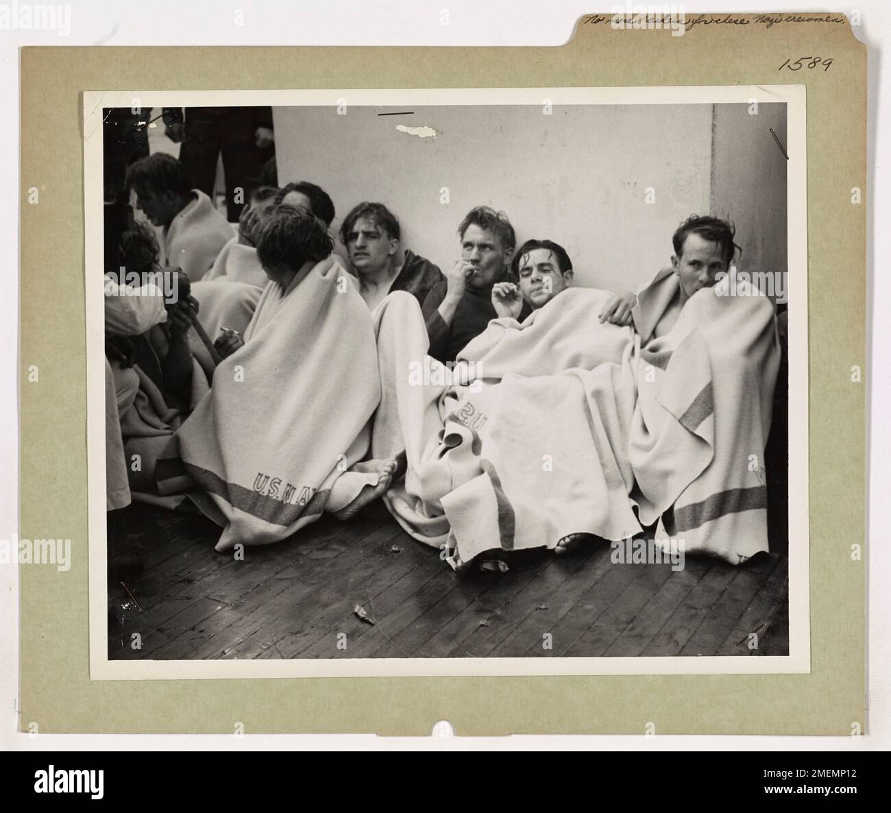Gefangengenommene deutsche Seeleute, die zuvor Teil einer U-Boot-Besatzung waren, befinden sich jetzt an Bord eines Cutters der Küstenwache. Die Rolle der Küstenwache bei der Gefangennahme und dem Transport von Kriegsgefangenen wird dargestellt, was die Bedeutung der Operationen der Küstenwache während des Zweiten Weltkriegs unterstreicht. Stockfoto