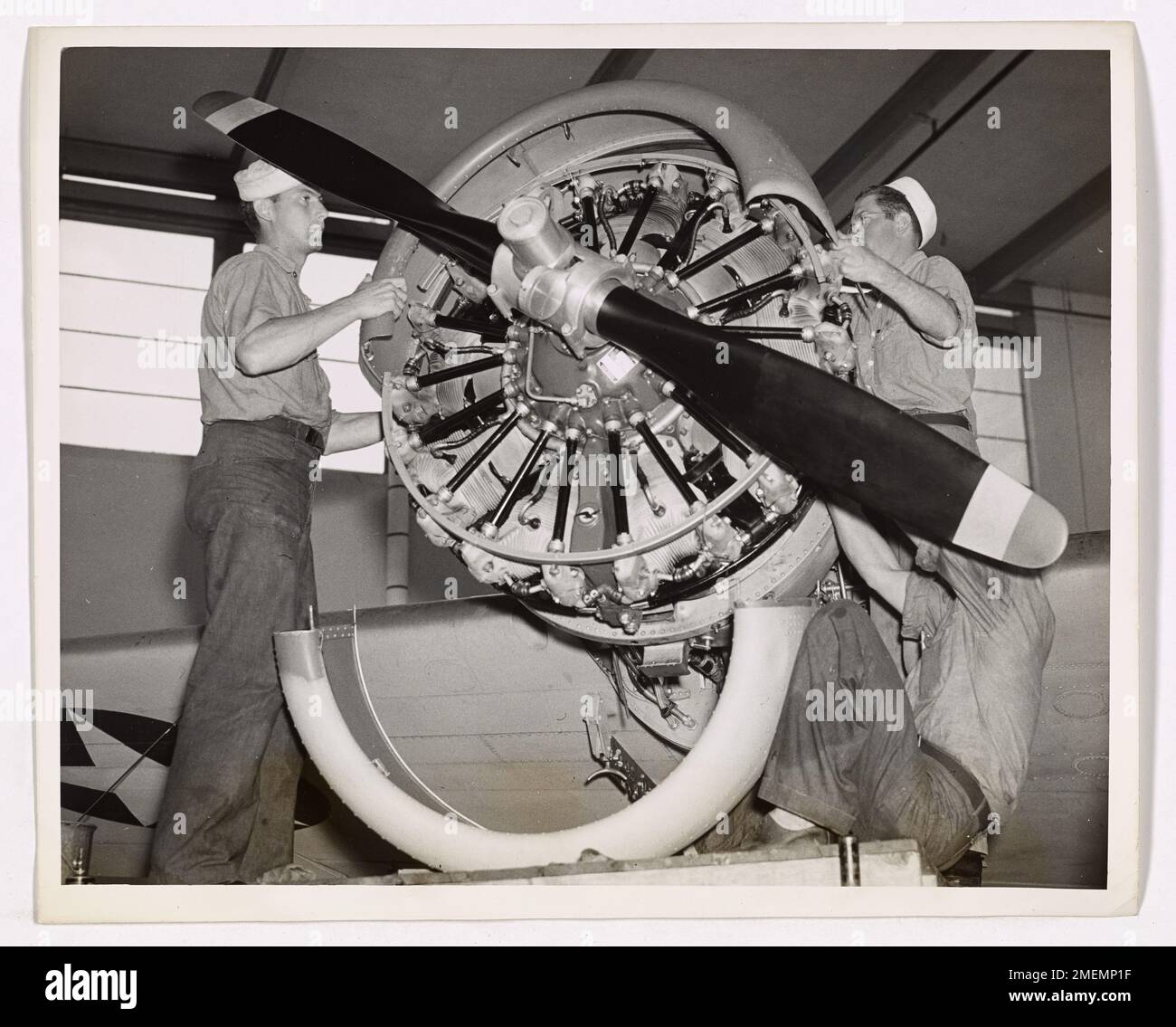 Diese Abbildung zeigt die Verknüpfungen des Maschinenführers, die Wartungsprüfungen durchführen und einen Flugzeugmotor überholen. Die Vorbereitung ist Teil der Routinewartung und stellt sicher, dass das Flugzeug für Flugreisen bereit ist, wobei das technische Know-how des Personals der Küstenwache hervorgehoben wird. Stockfoto