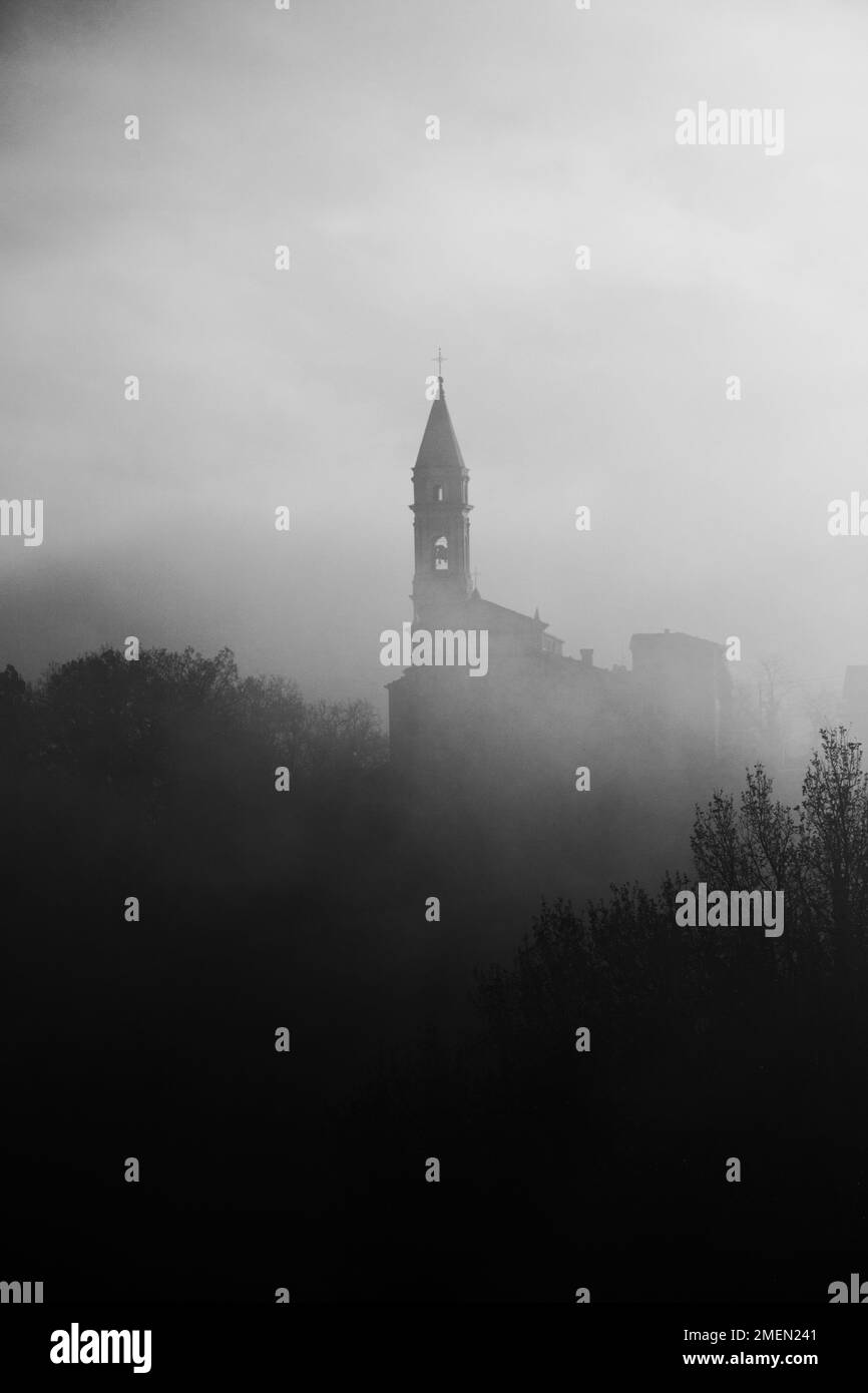 Die Kirche des Mysteriums, eine alte Kirche in den toskanisch-emilischen Apenninen, umhüllt von Nebel Stockfoto