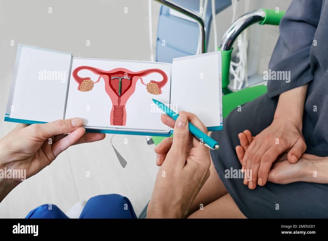 IUD. Erfahrener Gynäkologe zeigt der Patientin während der Sprechstunde ein intrauterines Kontrazeptivum oder eine Spule, um eine Schwangerschaft zu verhindern Stockfoto