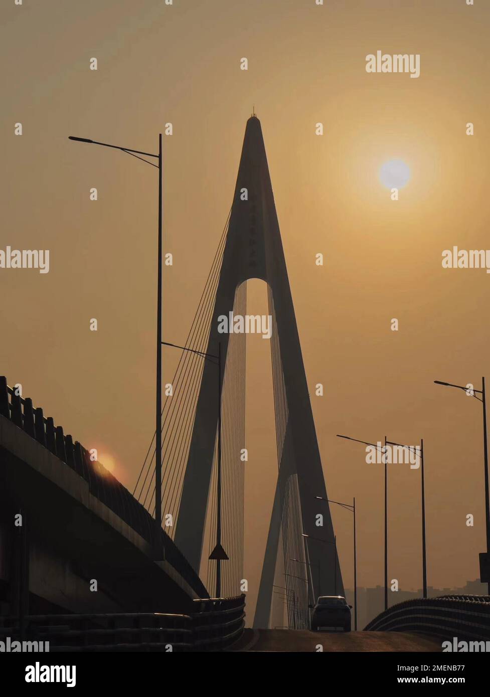 Ein Auto fährt auf dem Viadukt in Richtung der untergehenden Sonne. Chongqing, China. Stockfoto