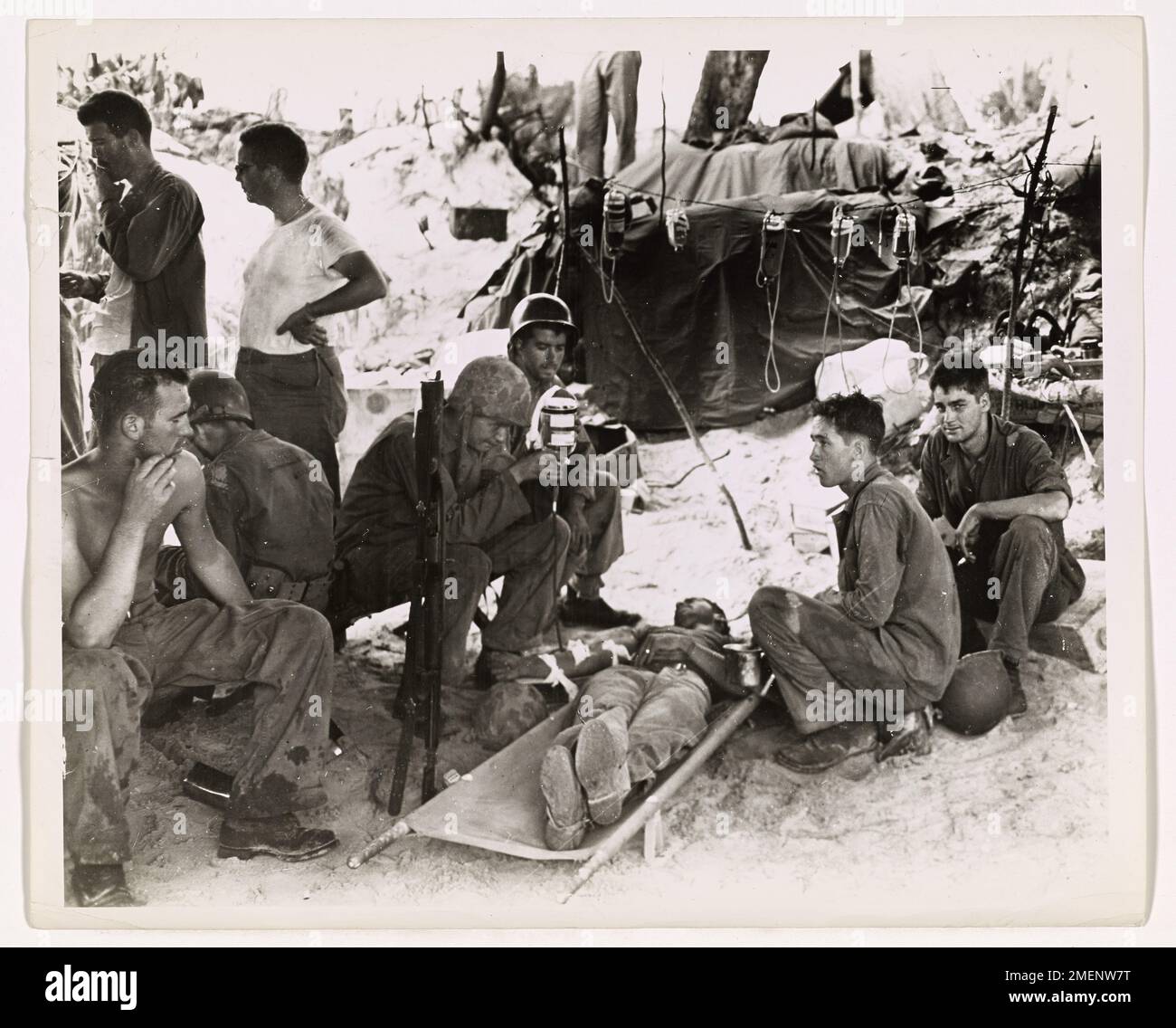 Während der Invasion von Saipan erhält ein Marine eine Blutplasmainjektion in einer erste-Hilfe-Station. Diese lebensrettende Behandlung, die von den Küstenwächtern bereitgestellt wurde, half, die Verluste zu reduzieren, indem sie das Leben vieler Soldaten, Seeleute und Marines während der Schlacht rettete. Stockfoto