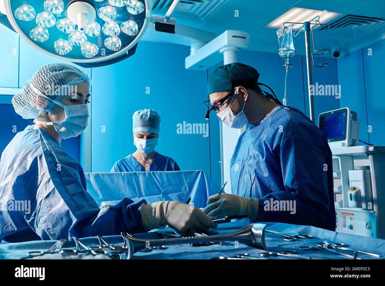 Operationsteam. Fokussierter Chirurg, der Patienten mit Assistenten im stationären Operationssaal operiert Stockfoto