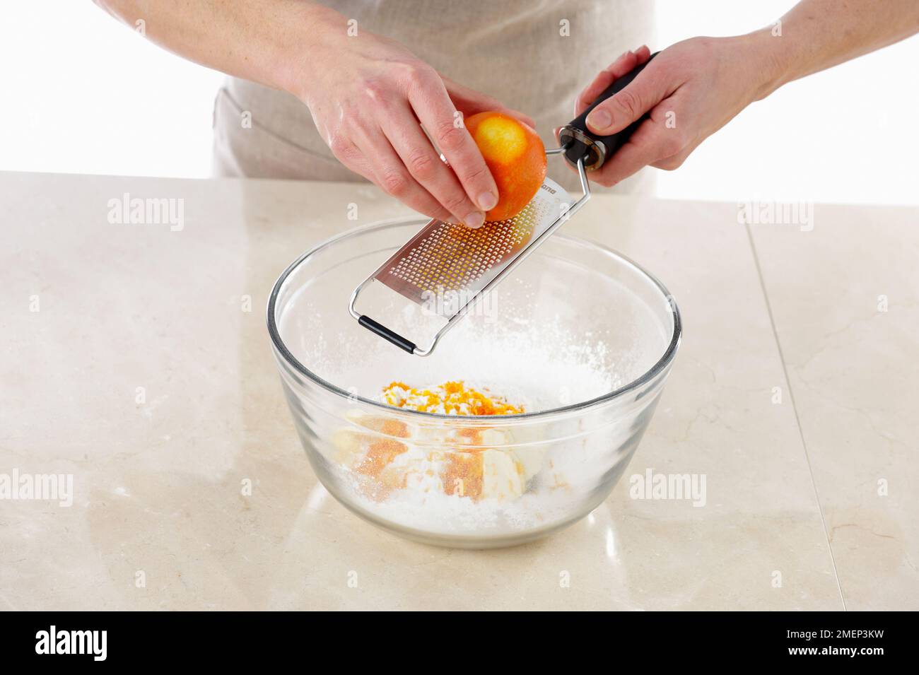 Karottenkuchen, Zuckerguss, Reiben von Orangenschale zu einer Mischung aus Butter, Frischkäse, Puderzucker und Vanille Stockfoto