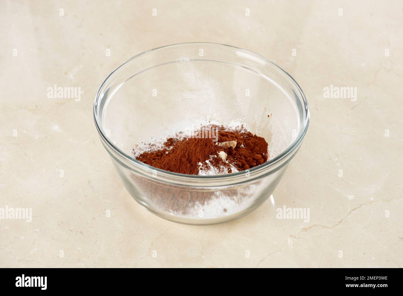 Schokoladenkuchen, der Buttercreme, Butter, Puderzucker und Kakaopulver in der Schüssel macht Stockfoto