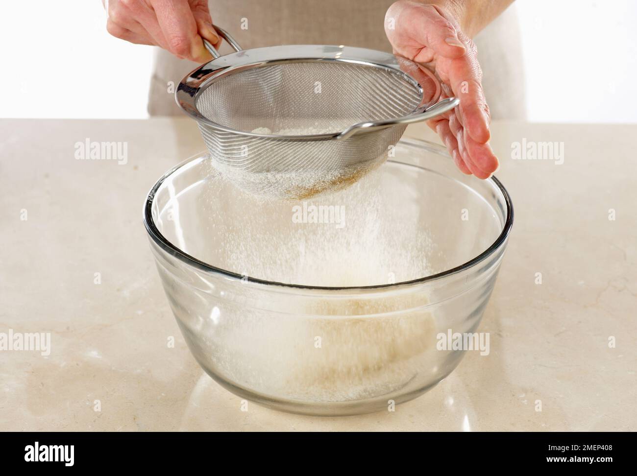 Herstellung von Rhubarb und Ingwer Upside Down Cake, Sieben von Mehl, gemahlenem Ingwer und Backpulver Stockfoto