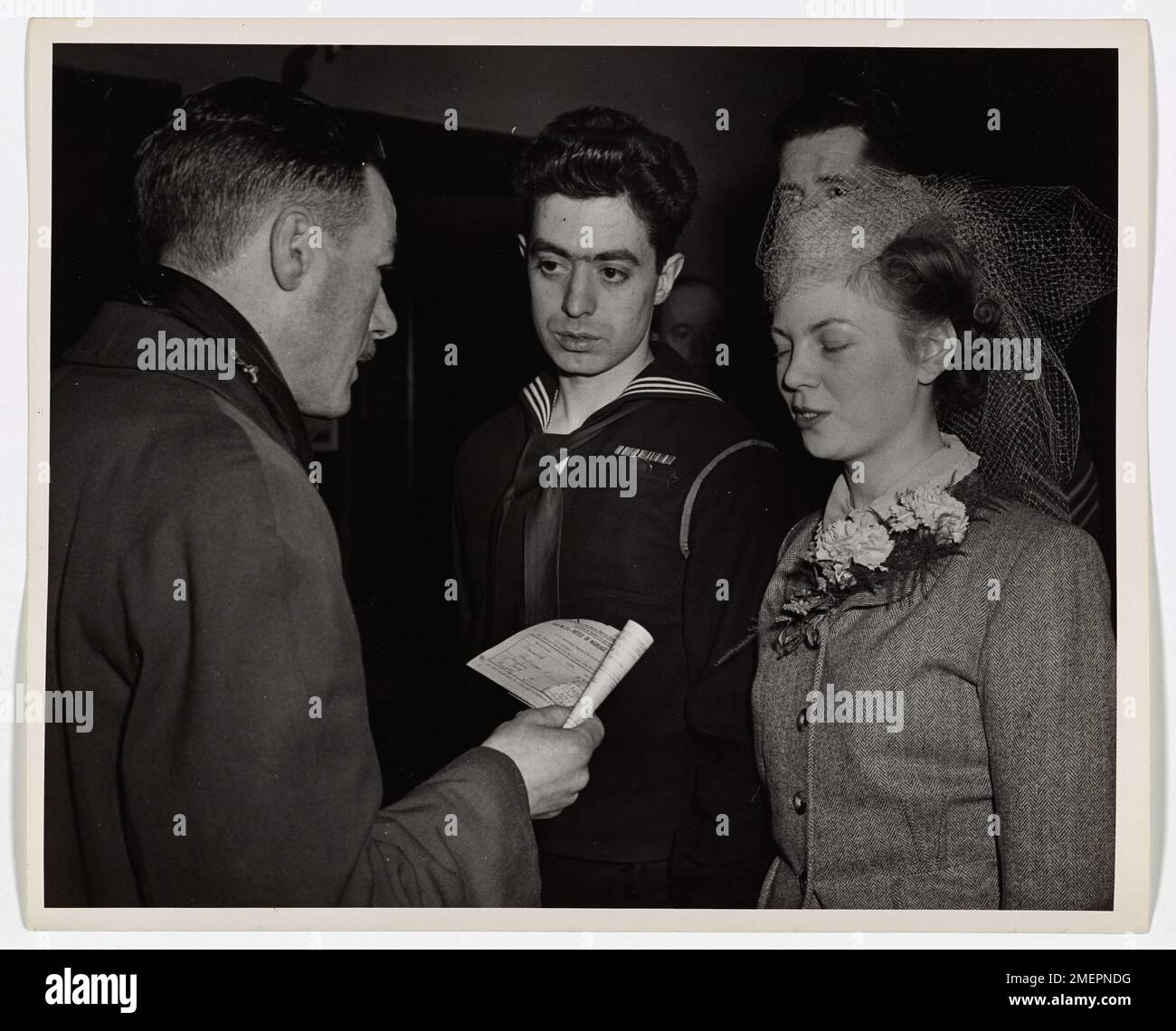 Der Küstenwächter Dominick Andreacci und der englische Wren Josephine Mary Kennelly erscheinen nach ihrer Hochzeit in einer Liverpool Kirche vor der Zivilbehörde für eine zweite Zeremonie. Das Ehepaar, das jetzt verheiratet ist, freut sich auf ein Nachkriegsleben in Brooklyn, New York. Andreacci bekundet sein Engagement, trotz seiner neuen Ehe im Dienst zu bleiben. Stockfoto