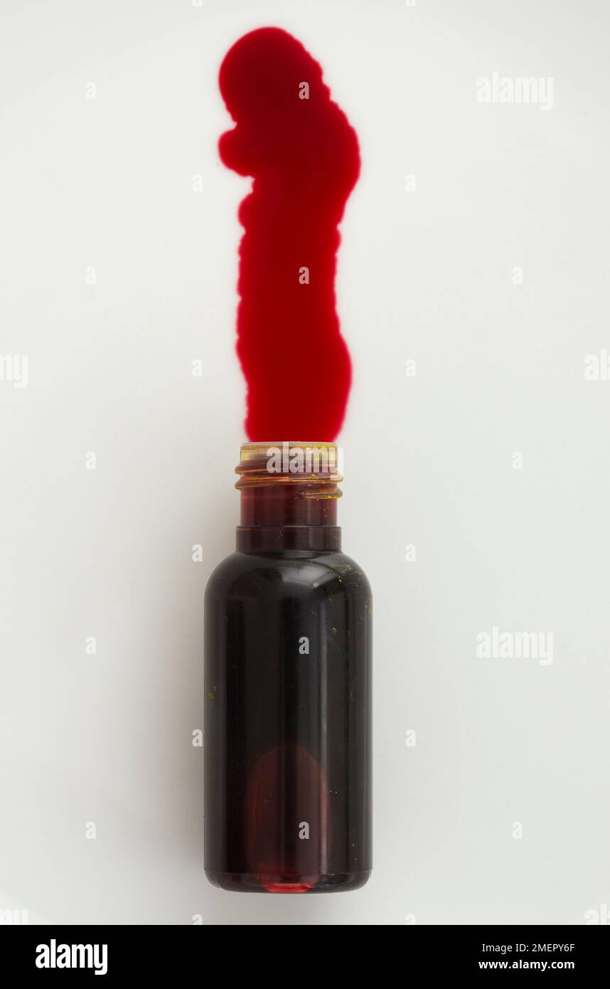 Roter Farbstoff, der aus der kleinen Flasche austritt, Draufsicht Stockfoto