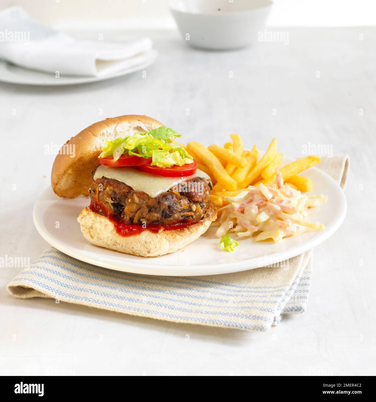 Aduki-Bohnen-Gemüse-Burger im Brötchen, mit Krautsalat und Pommes frites Stockfoto