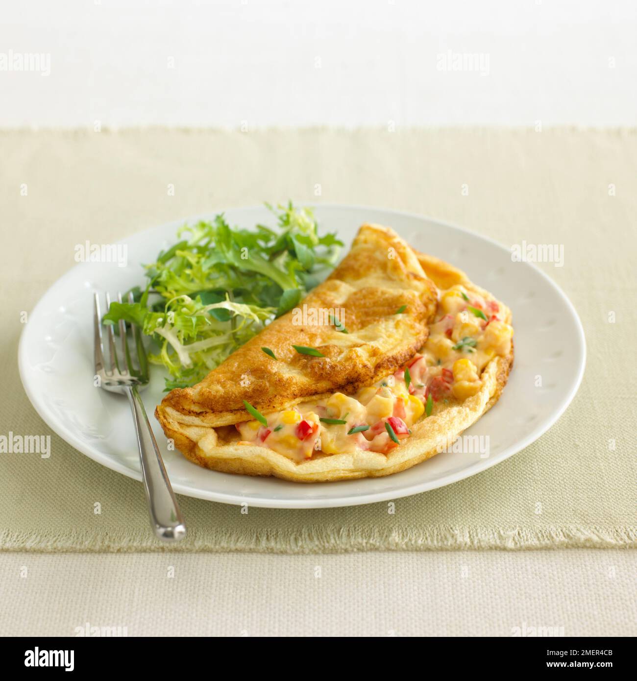 Käsesoufflé-Omelette mit Zuckermais, Paprika und Schnittlauch Stockfoto