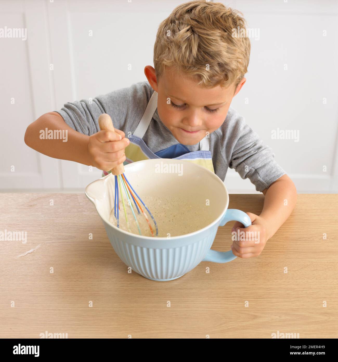 Junge, der Pfannkuchen-Mixgetränk macht, 4 Jahre Stockfoto