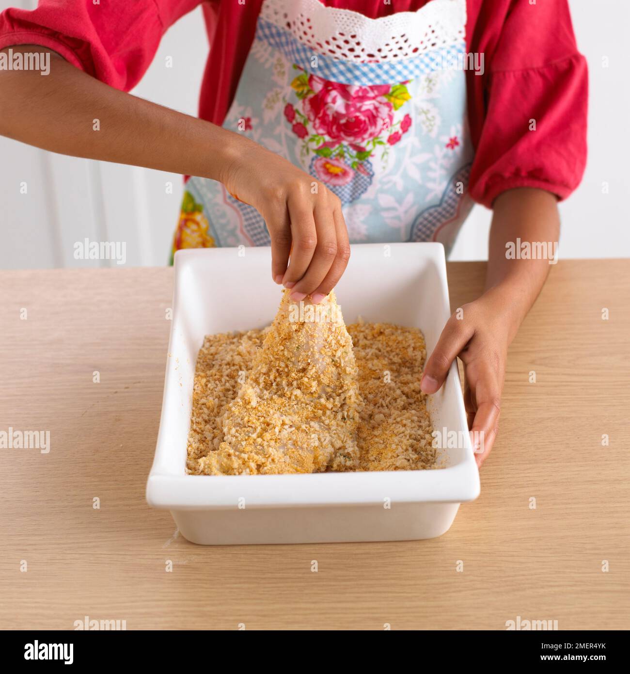 Ein Mädchen, das Fisch in Brotkrumen erstickt, 8 Jahre Stockfoto Ein Mädchen, das Fisch in Brotkrumen erstickt, 8 Jahre Stockfoto