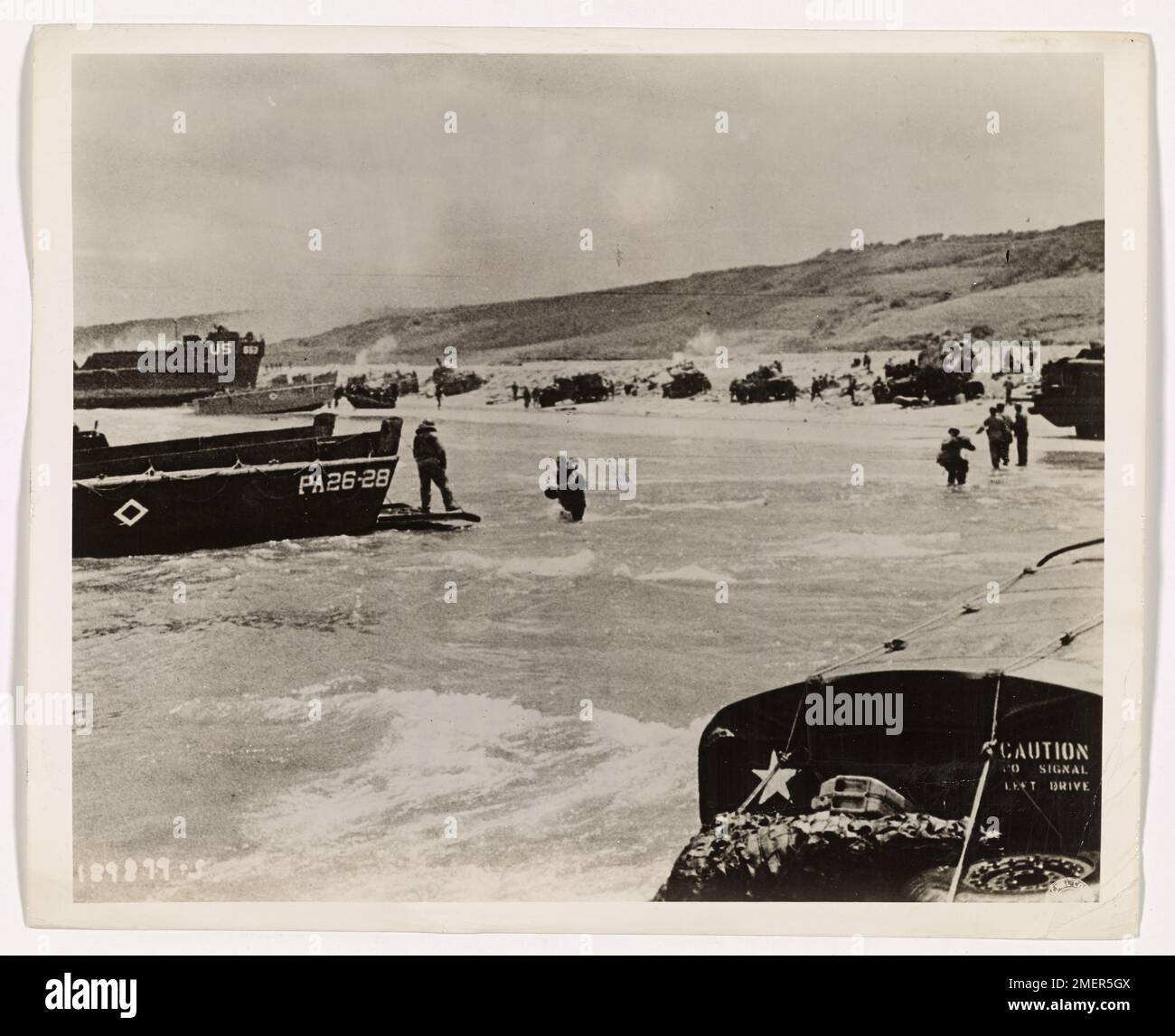 Panzer Rollen in den frühen Morgenstunden des D-Day vom Landungsboot der Küstenwache auf den Sand der Normandie. Der Landangriff folgt einem heftigen Marineangriff, bei dem Panzer und mechanisierte Ausrüstung schnell eingesetzt wurden, um die erfolgreiche Einrichtung der alliierten Streitkräfte an der französischen Küste zu unterstützen. Stockfoto