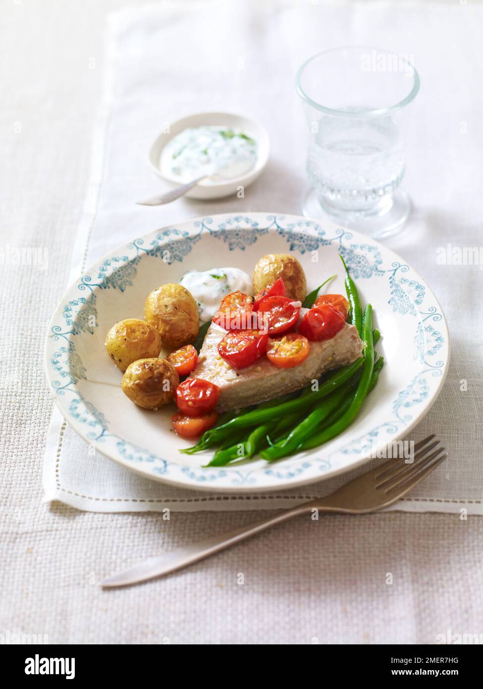 Gebackener Fisch und Tomaten, Kartoffeln und grüne Bohnen Stockfoto