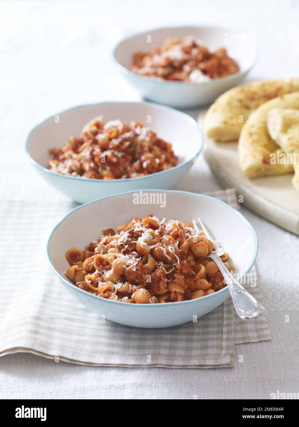 Drei Schüsseln Würstchen Conchigliette und geriebenem Käse, Kinderfutter Stockfoto