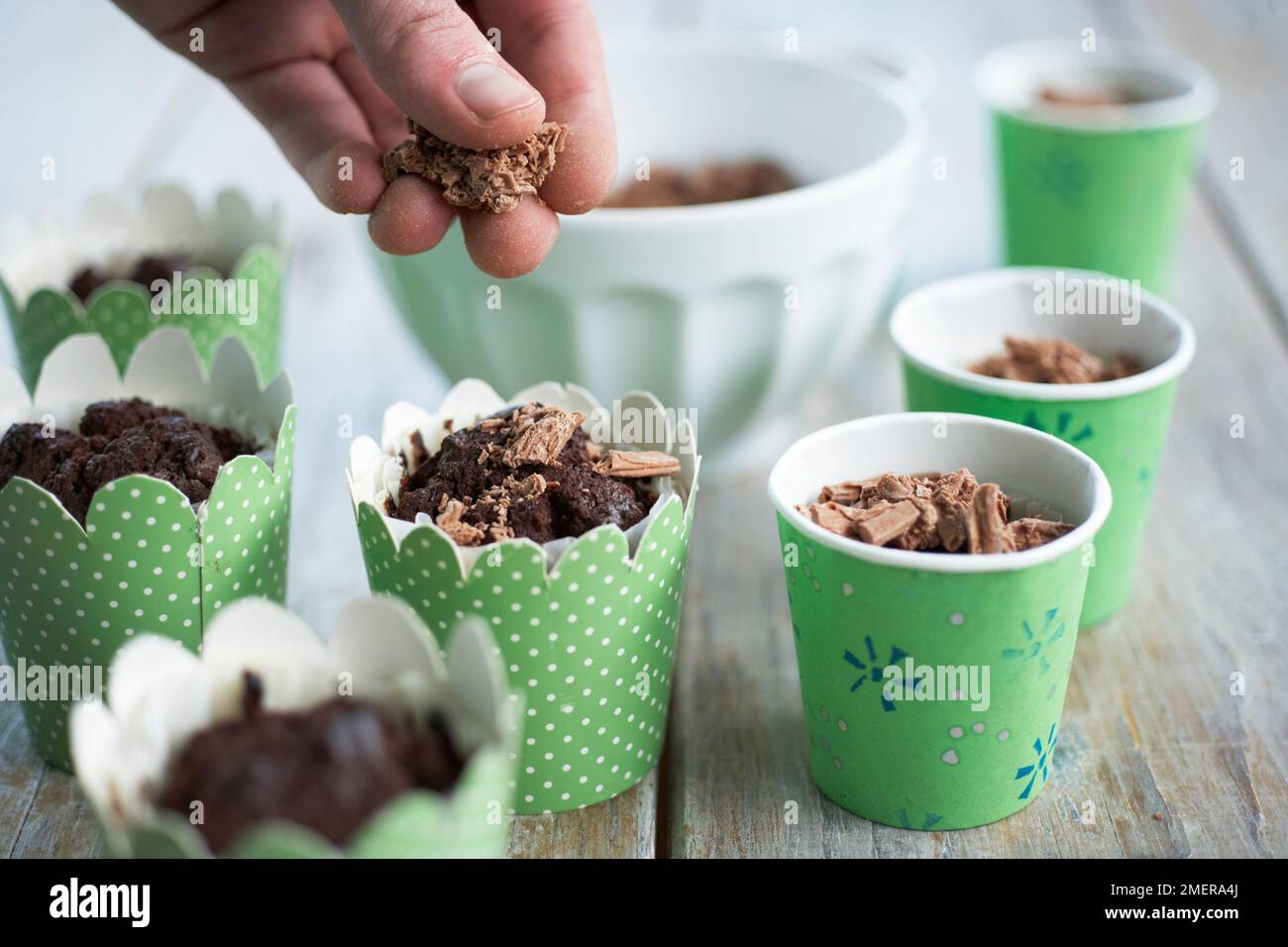 Verzierung der Oberteile von Blumentopf-Kuchen mit geriebener Schokolade Stockfoto