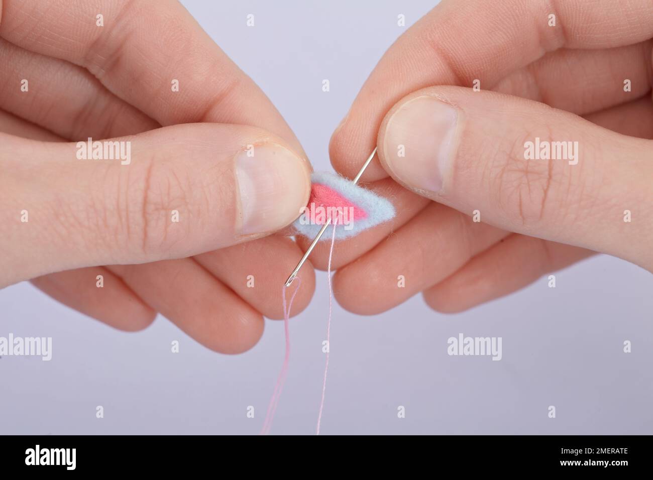 Filz-Fingerpuppen, Innenohr an Außenohr nähen Stockfoto