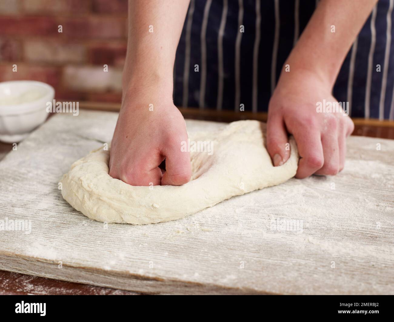 Brot zubereiten, Teig auf Mehlfläche kneten Stockfoto