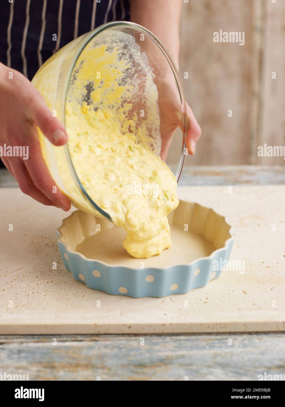 Maisbrot, Maisbrotmischung in eine große runde Backform gießen Stockfoto