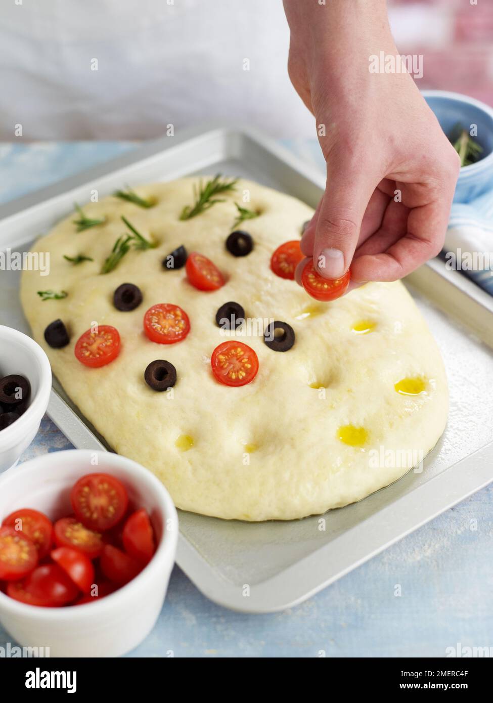 Stopfen Sie Focaccia-Brot mit Rosmarin, Oliven und Kirschtomaten, Olivenöl Stockfoto