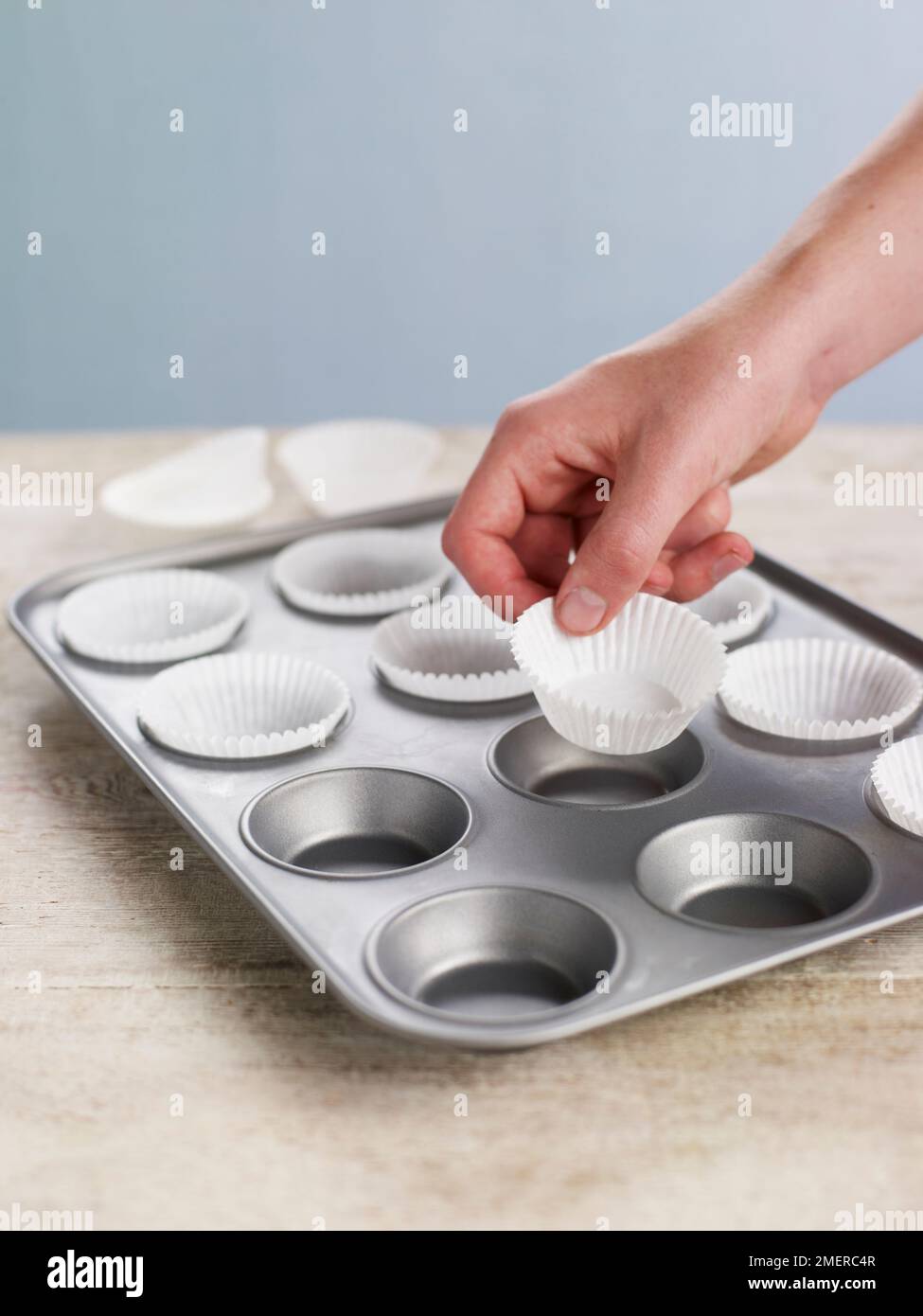 Brötchendose mit Papierkästen auskleiden, Cupcakes backen Stockfoto