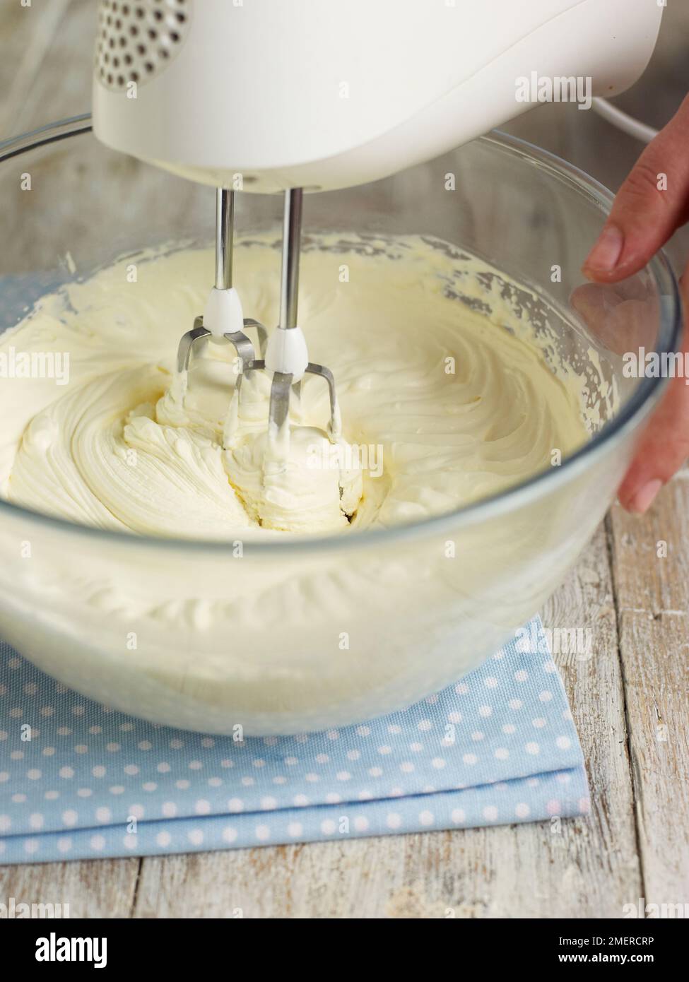 Mit dem Handmixer den Teig in einer großen Schüssel schlagen Stockfoto
