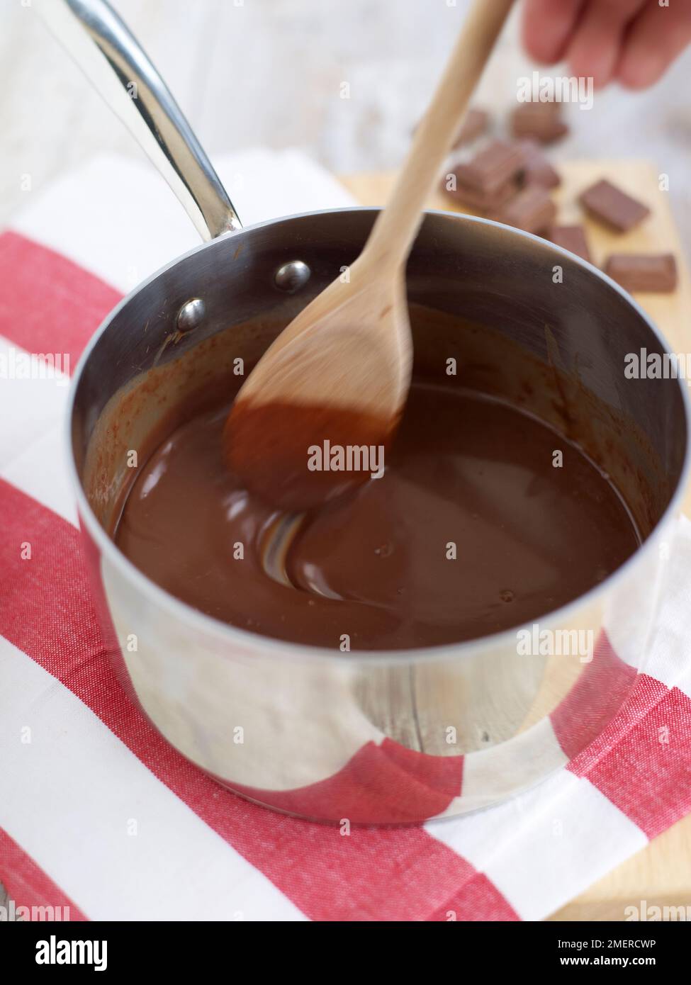 Geschmolzene Schokolade in einem Topf umrühren Stockfoto