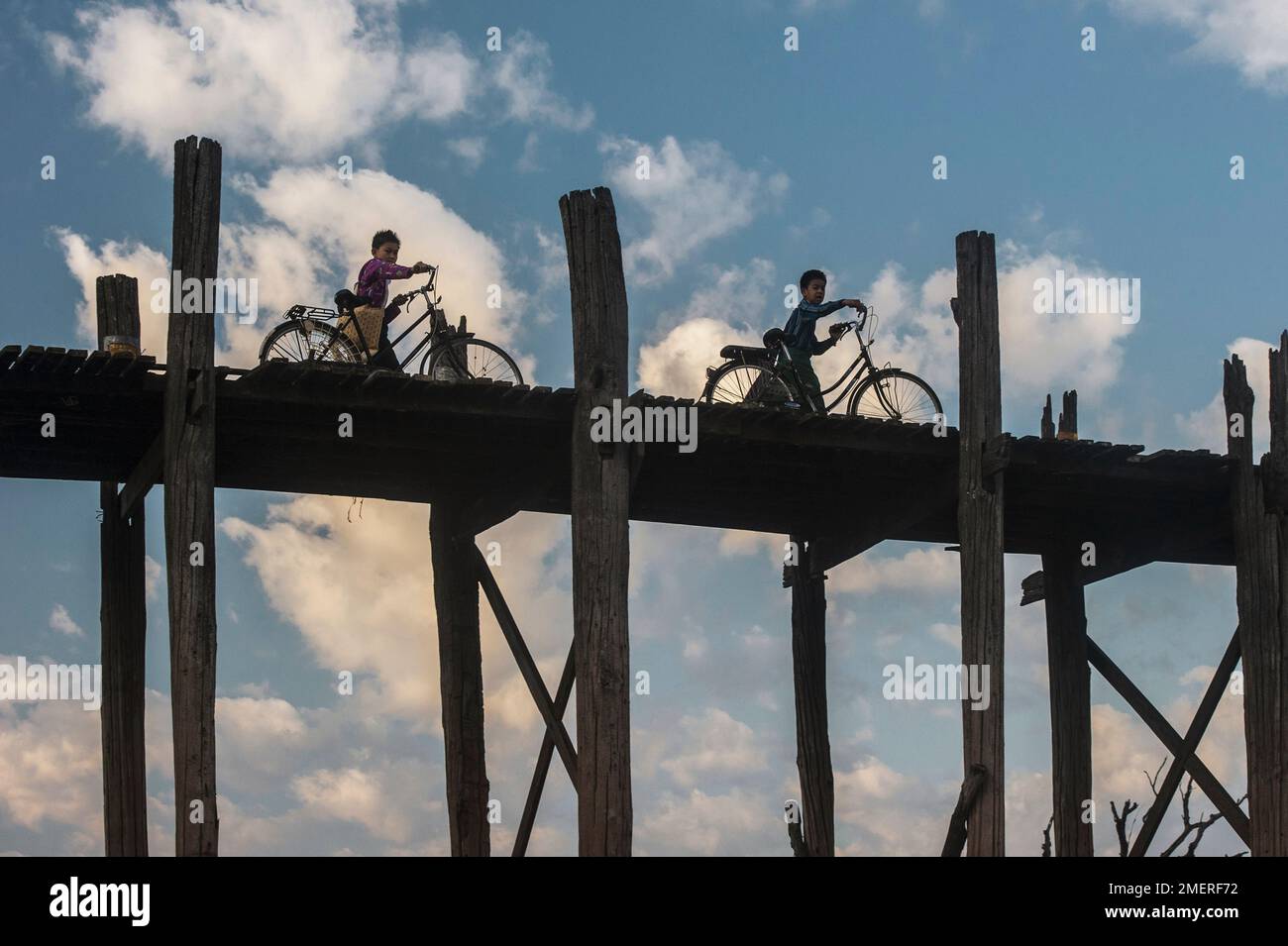 Myanmar, Mandalay, Amarapura, Kinder, die bei Sonnenaufgang ihre Fahrräder über die U-Beins-Brücke schieben Stockfoto