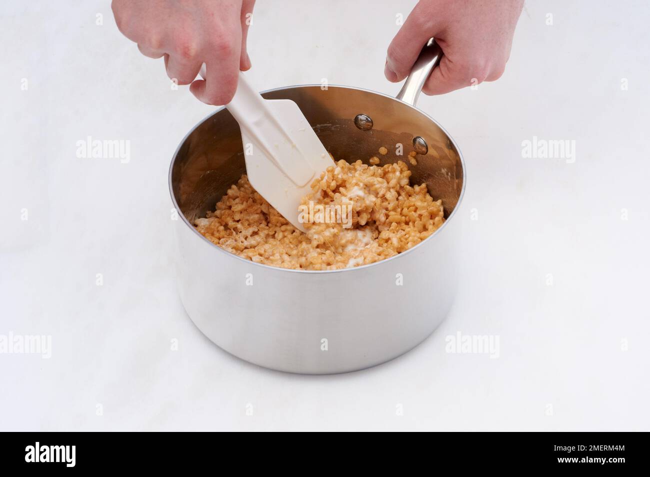 Mischen Sie Butter-Marshmallows und Reiskrispies in einem Topf Stockfoto