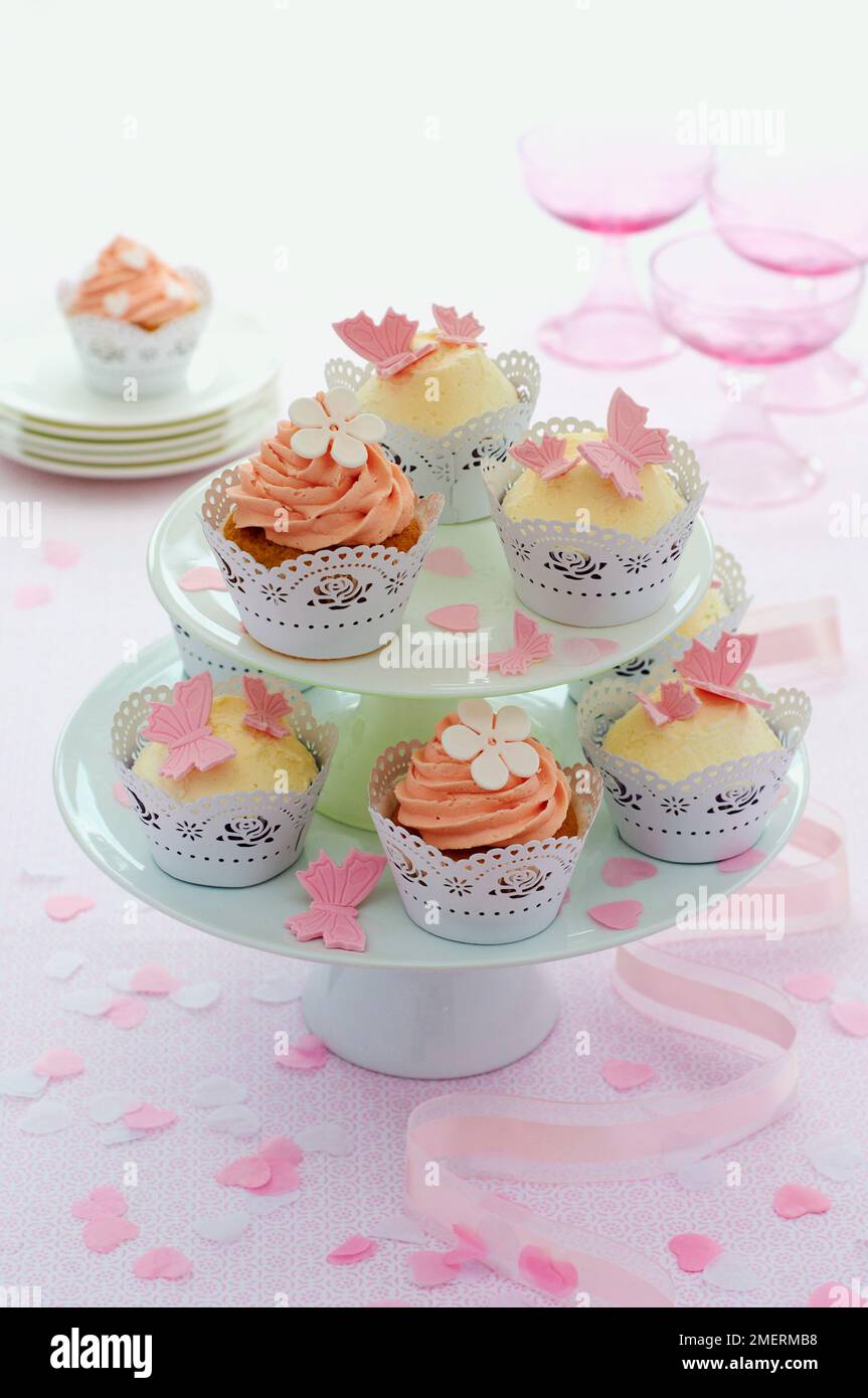 Köstlich dekorierte Cupcakes auf einem zweistufigen Kuchenstand Stockfoto