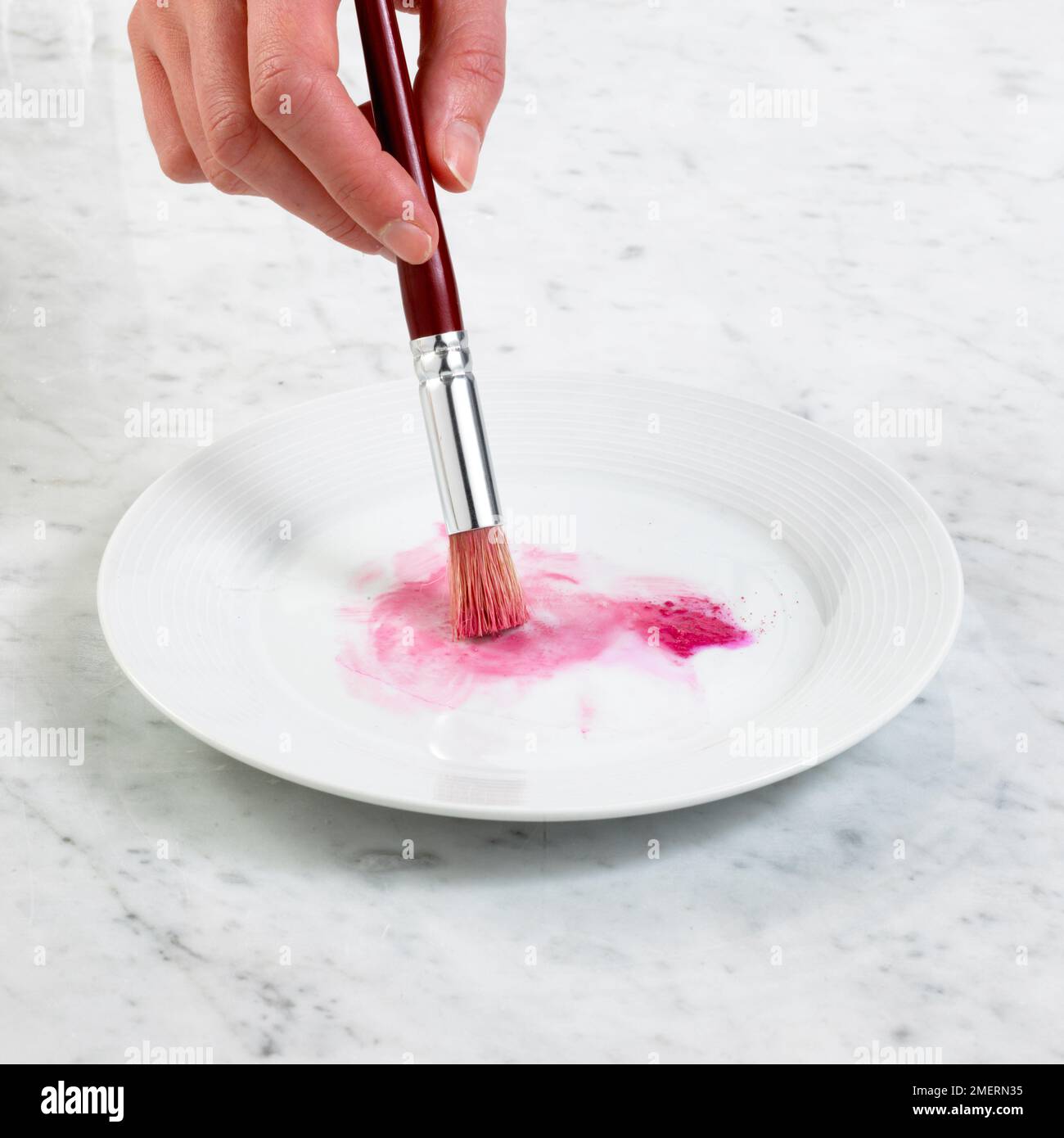 Zubereitung der Lebensmittelfärbung mit einem Pinsel Stockfoto