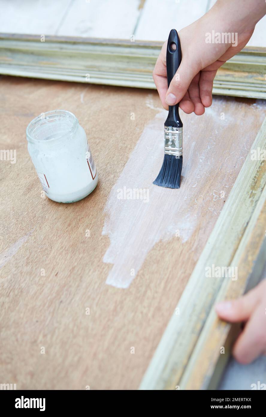 PVA-Lösung über einer Pflanzmaschine mit Bilderrahmen aus Sperrholz abbürsten Stockfoto