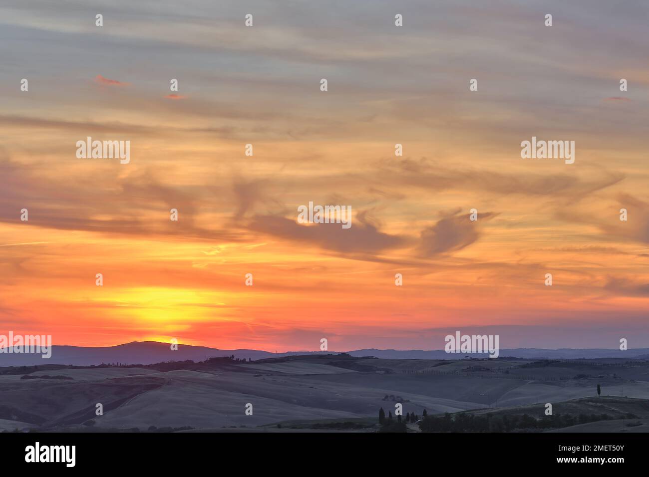 Toskanischer Sonnenuntergang mit sanften Hügeln in der Ferne, Toskana, Italien. Stockfoto