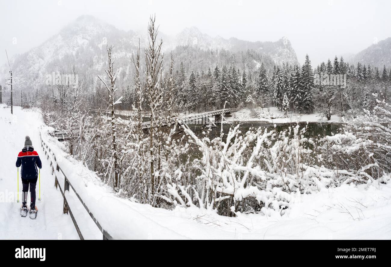 Schneeschuhwandern in Winterlandschaft, Brücke über den Fluss Enns, in der Nähe von Admont, Gesaeuse Nationalpark, Steiermark, Österreich Stockfoto