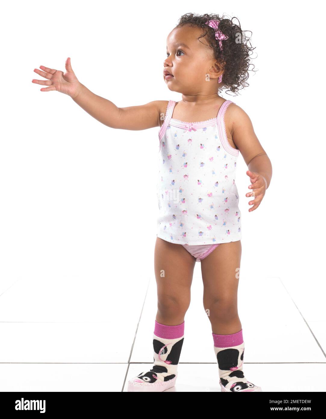 Mädchen mit Weste, Hosen und Hausschuhen, 16 Monate, Stockfoto