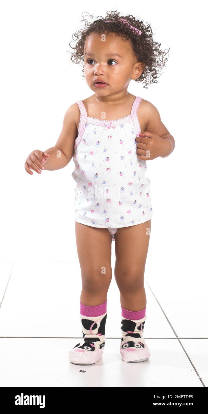 Mädchen mit Weste, Hosen und Hausschuhen, 16 Monate Stockfoto