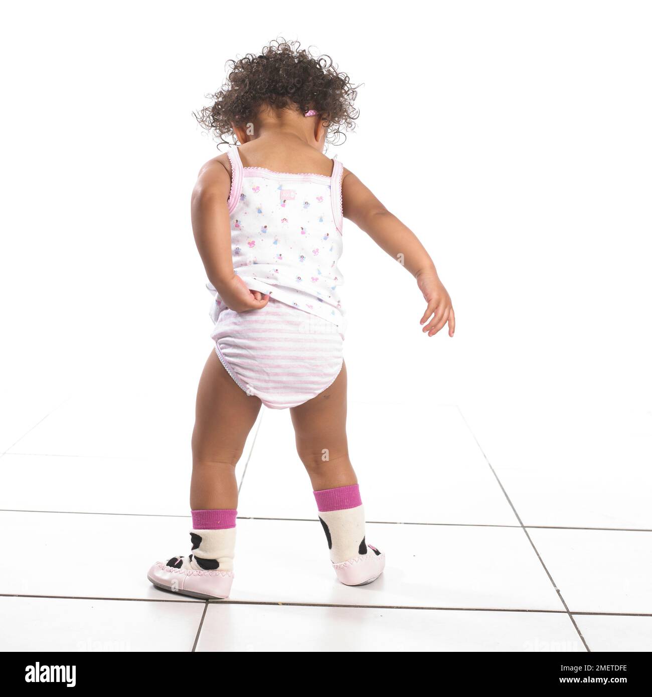 Mädchen mit Hosen, Weste und Hausschuhen, Rückansicht, 16 Monate Stockfoto