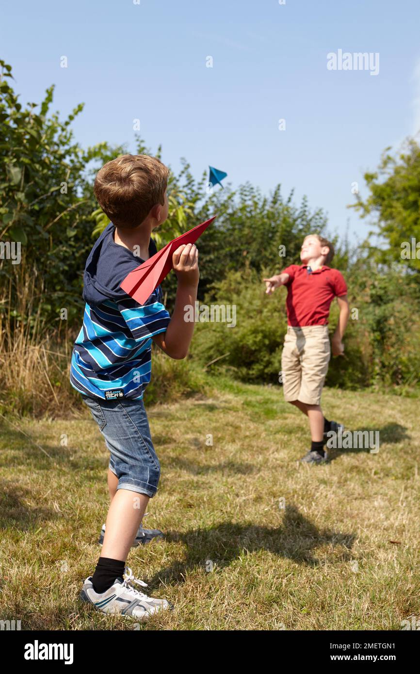 Jungen spielen mit Papierflieger Stockfoto