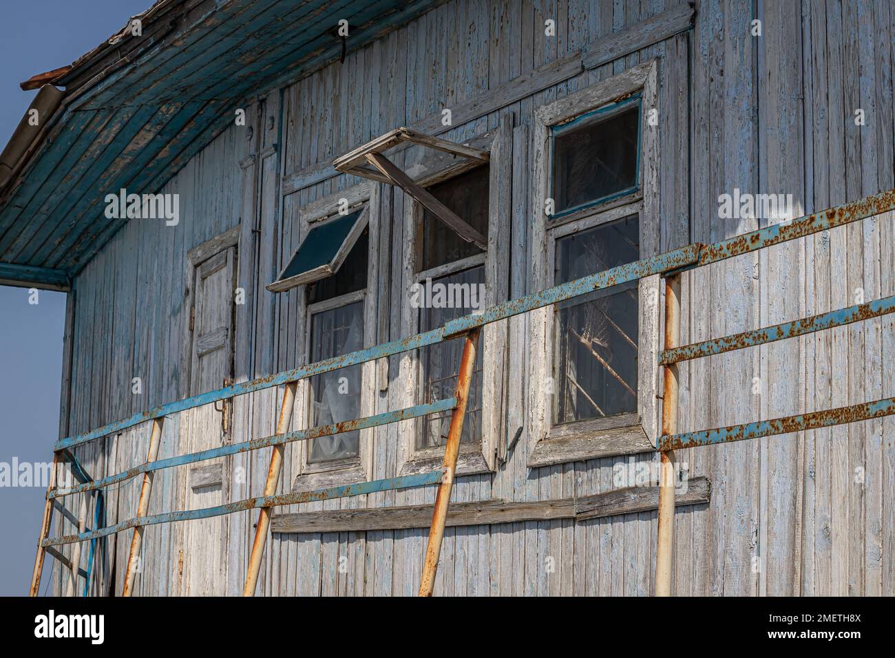 Das Fenster des alten Holzhauses auf dem Hintergrund von Holzwänden. Stockfoto